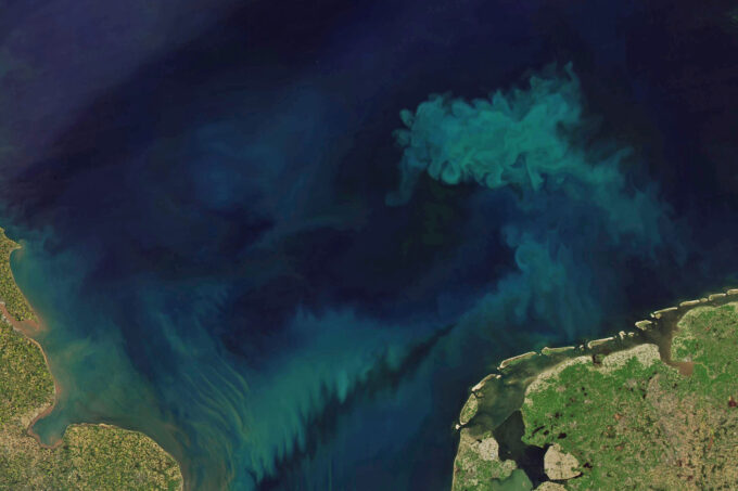 The North Sea via satellite. The dark blue water has swirls of teal, and Germany peeks out from the bottom right.